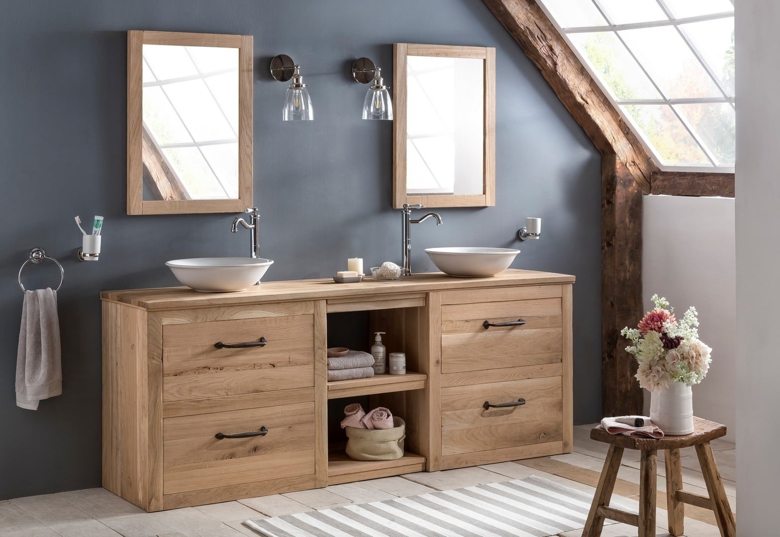 Landelijke badkamer van eiken met twee keramische waskommen voorzien van bijpassende spiegels.
