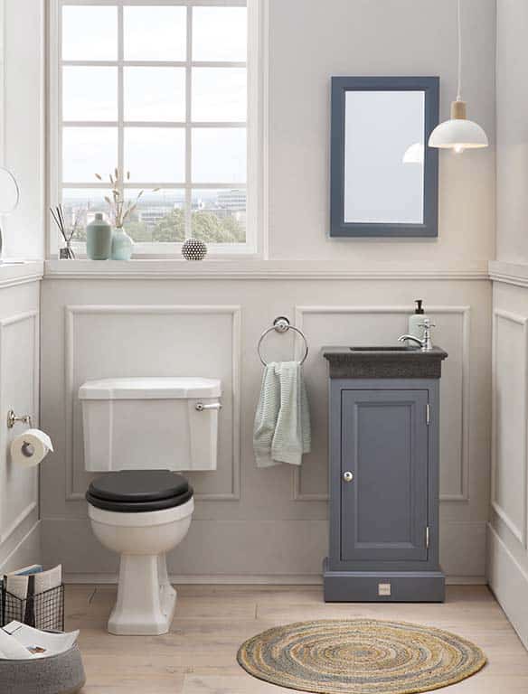 staand toiletmeubel van massief hout met granieten fontein en bijpassende spiegel in de toiletruimte