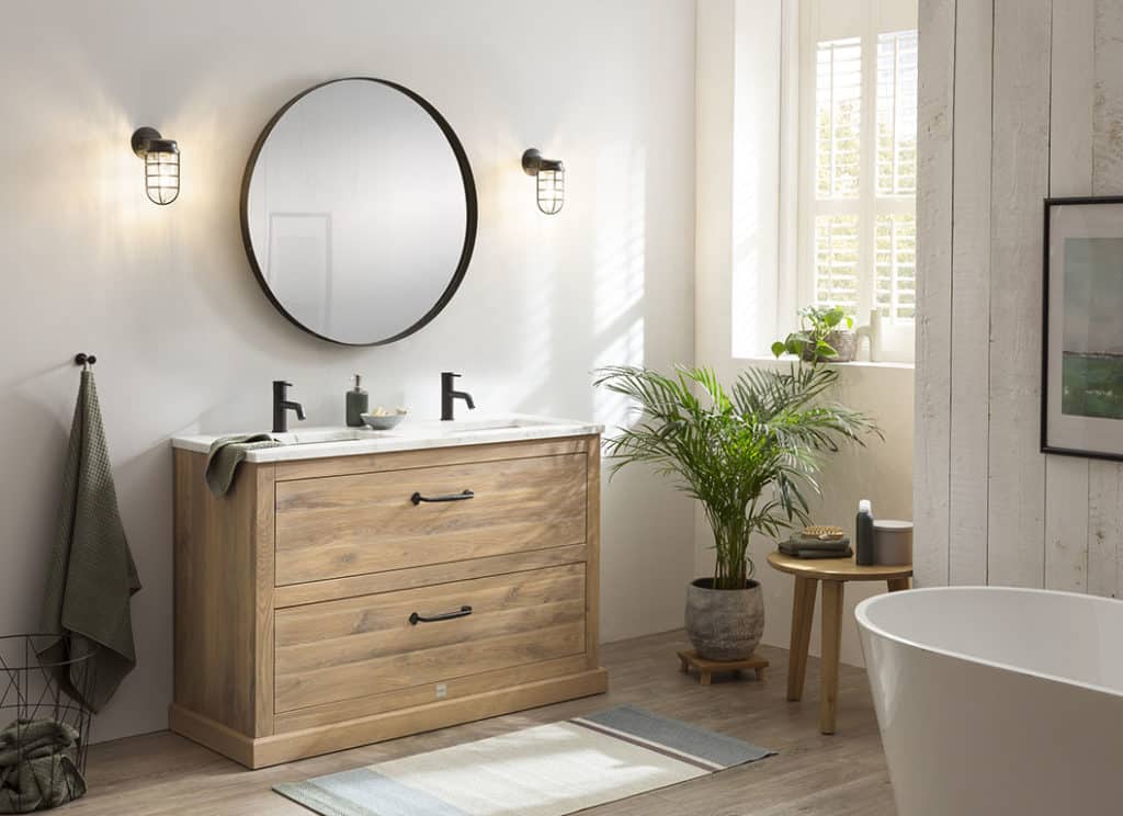 Echt hout in de badkamer bij een staand badkamermeubel van massief hout met een zwarte spiegel en twee zwarte wastafelkranen