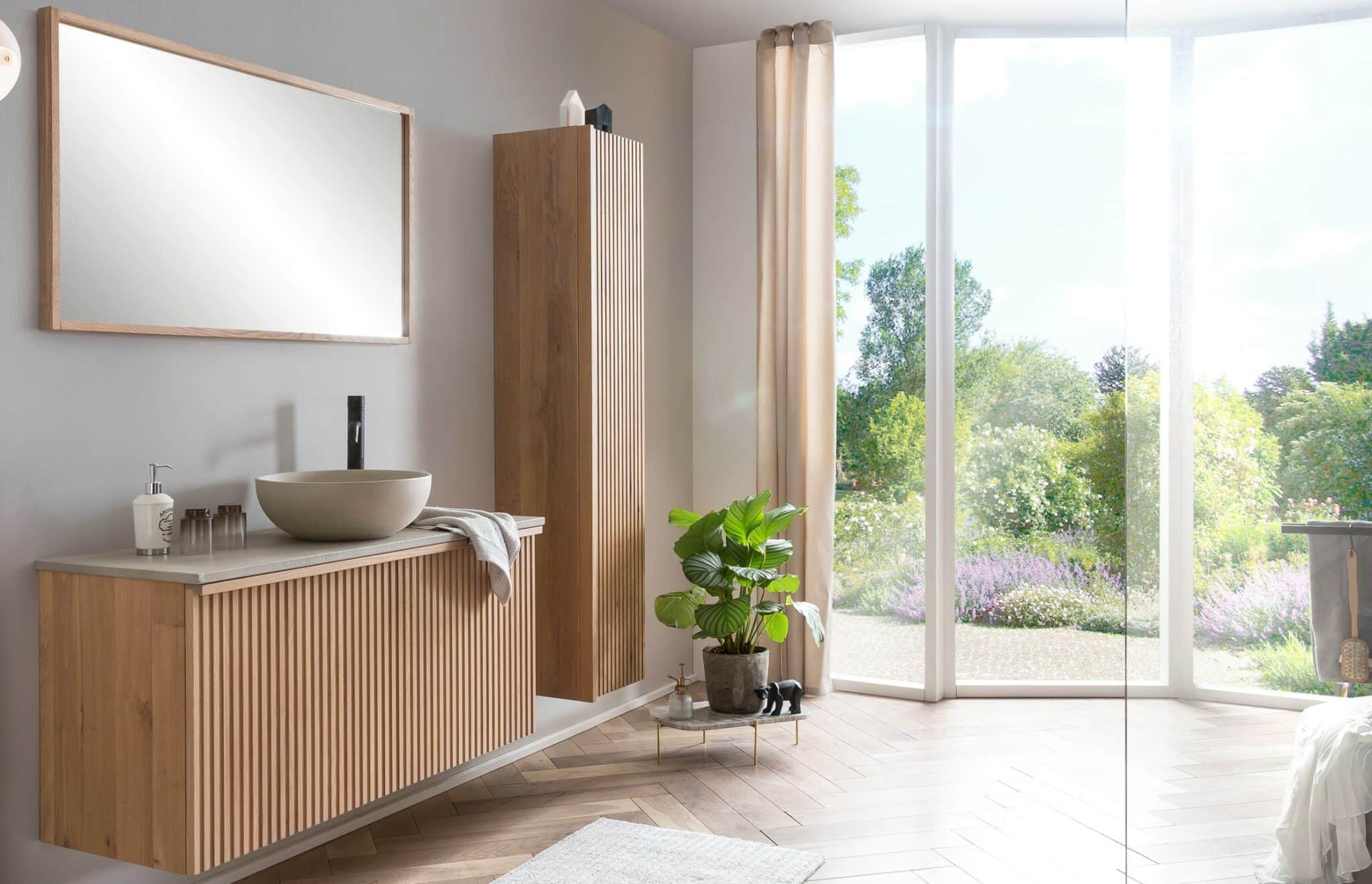 Een hotel chique badkamer met een massief houten badkamermeubel, een houten kolomkast, en een houten spiegel. Op het badmeubel is een betonnen wastafelblad en een betonnen waskom