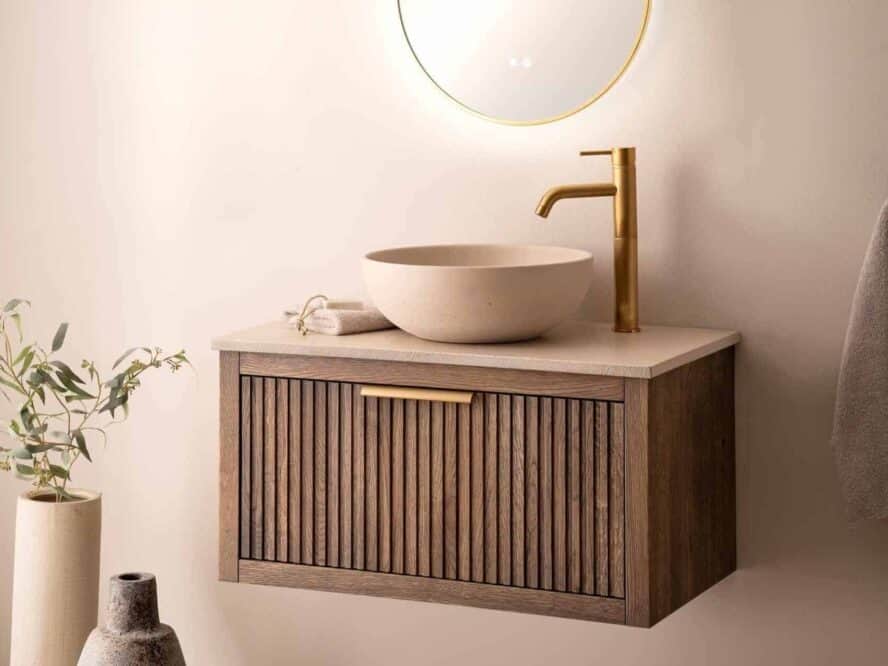 Hangend badmeubel met met ribbelfront in de kleur donker met een betonnen waskom in de kleur beige op een wastafelblad van beton in de kleur beige.