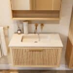 Het Hallberg badkamermeubel 80 in naturel eiken straalt warmte en karakter uit. De softclose-lade biedt praktische opbergruimte, terwijl de betonnen wastafel in Beige zorgt voor een elegante, tijdloze uitstraling. Een ambachtelijk meubel dat perfect