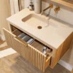 Het Hallberg badkamermeubel 80 in naturel eiken straalt warmte en karakter uit. De softclose-lade biedt praktische opbergruimte, terwijl de betonnen wastafel in Beige zorgt voor een elegante, tijdloze uitstraling. Een ambachtelijk meubel dat perfect