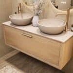 Hangend naturel eiken wastafelmeubel 120 cm met enkele lade en limestone blad met twee witte waskommen