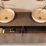 Rond hangend donker eiken badkamermeubel 160 cm met vlak front, eiken blad en beige limestone waskom