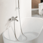 Moderne thermostatische bad/douchekraan in chroom, geleverd als complete set met handdouche, doucheslang en wandhaak. Onderdeel van de Riva Bella serie, verkrijgbaar in 6 kleuren en direct uit voorraad leverbaar.