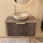 Rond hangend donker eiken badkamermeubel 80 cm met groevenfront, eiken blad en beige limestone waskom