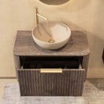 Rond hangend donker eiken badkamermeubel 80 cm met groevenfront, eiken blad en beige limestone waskom