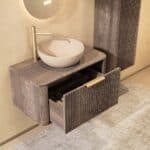 Rond hangend donker eiken badkamermeubel 80 cm met groevenfront, eiken blad en beige limestone waskom
