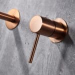 Moderne muurwastafelkraan in geborsteld koper voor wandmontage boven een wastafel of waskom, geleverd als complete set inclusief bijpassende clickwaste met duurzame PVD-coating. De clickwaste is een handige pop-up afvoer die je eenvoudig opent en slu
