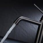 Moderne lage wastafelkraan in black gun metal voor een badmeubel met wastafel, geleverd als complete set inclusief bijpassende clickwaste met duurzame PVD-coating. De clickwaste is een handige pop-up afvoer die je eenvoudig opent en sluit door erop t