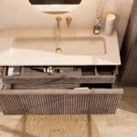 Hangend donker eiken badmeubel 120 cm met vlak front, binnenlade en beige limestone wastafel