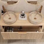 Rond hangend naturel eiken wastafelmeubel 120 cm met groevenfront en twee beige marmerlook waskommen