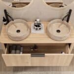 Rond hangend naturel eiken wastafelmeubel 120 cm met afgeronde hoeken en twee beige marmerlook waskommen