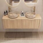 Rond hangend naturel eiken wastafelmeubel 140 cm met afgeronde hoeken en twee beige marmerlook waskommen