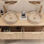 Rond hangend naturel eiken wastafelmeubel 140 cm met afgeronde hoeken en twee beige marmerlook waskommen