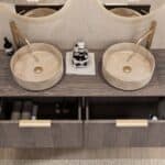 Rond hangend donker eiken wastafelmeubel 140 cm met afgeronde hoeken en twee beige marmerlook waskommen