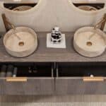 Rond hangend donker eiken wastafelmeubel 160 cm met afgeronde hoeken en twee beige marmerlook waskommen