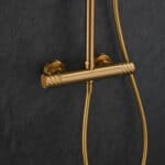 Luxe opbouwdoucheset in geborsteld goud met PVD-coating, thermostatische douchekraan en hoofddouche van Ø20 cm. Inclusief handdouche. Verkrijgbaar in 6 kleuren en 5 jaar garantie. Kenmerkend voor de Toscana serie is het gedraaide reliëf op de bedieni