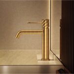 Moderne lage wastafelkraan in geborsteld goud voor een badmeubel met wastafel, geleverd als complete set inclusief bijpassende clickwaste met duurzame PVD-coating. De clickwaste is een handige pop-up afvoer die je eenvoudig opent en sluit door erop t