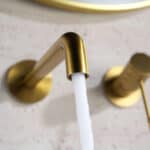 Moderne muurwastafelkraan in geborsteld goud voor wandmontage boven een wastafel of waskom. Voorzien van een duurzame PVD-coating, 5 jaar garantie en verkrijgbaar in 6 kleuren. Kenmerkend voor de Toscana serie is het gedraaide reliëf op de bediening: