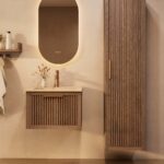 Het Riva badkamermeubel 60 in donker eiken ademt luxe en rust. Massief eiken met groevenfront, hoogwaardige softclose lades en een mat beige Mineraalsteen wastafel. De wastafel kan met of zonder kraangaten worden geleverd.