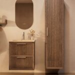 Het Riva badkamermeubel 60 in donker eiken ademt luxe en rust. Massief eiken met groevenfront, twee hoogwaardige softclose lades en een mat beige Mineraalsteen wastafel. De wastafel kan met of zonder kraangaten worden geleverd.