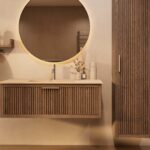 Het Riva badkamermeubel 120 in donker eiken ademt luxe en rust. Massief eiken met groevenfront, hoogwaardige softclose lades en een mat beige Mineraalsteen wastafel. De wastafel kan met of zonder kraangaten worden geleverd.