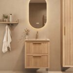 Het Riva badkamermeubel 60 in naturel eiken combineert ambachtelijk vakmanschap met moderne luxe. Gemaakt van massief eiken met ribbelfront, twee softclose lades en een mat beige Mineraalsteen wastafel. De wastafel kan met of zonder kraangaten worden
