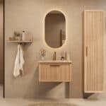Het Riva badkamermeubel 70 in naturel eiken combineert ambachtelijk vakmanschap met moderne luxe. Gemaakt van massief eiken met ribbelfront, softclose lades en een mat beige Mineraalsteen wastafel. De wastafel kan met of zonder kraangaten worden gele