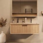 Het Riva badkamermeubel 120 in naturel eiken combineert ambachtelijk vakmanschap met moderne luxe. Gemaakt van massief eiken met ribbelfront, softclose lades en een dubbele mat beige Mineraalsteen wastafel. De wastafel kan met of zonder kraangaten wo