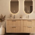 Het Riva badkamermeubel 160 in naturel eiken combineert ambachtelijk vakmanschap met moderne luxe. Gemaakt van massief eiken met ribbelfront, vier softclose lades en een mat beige dubbele Mineraalsteen wastafel. De wastafel kan met of zonder kraangat