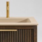 Het Riva badkamermeubel 160 in Donker eiken combineert ambachtelijk vakmanschap met moderne luxe. Gemaakt van massief eiken met ribbelfront, vier softclose lades en een mat beige dubbele Mineraalsteen wastafel. De wastafel kan met of zonder kraangate