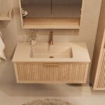 Het Riva badkamermeubel 100 in naturel eiken combineert ambachtelijk vakmanschap met moderne luxe. Gemaakt van massief eiken met ribbelfront, softclose lades en een mat beige Mineraalsteen wastafel. De wastafel kan met of zonder kraangaten worden gel