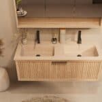Het Riva badkamermeubel 120 in naturel eiken combineert ambachtelijk vakmanschap met moderne luxe. Gemaakt van massief eiken met ribbelfront, softclose lades en een dubbele mat beige Mineraalsteen wastafel. De wastafel kan met of zonder kraangaten wo