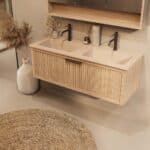 Het Riva badkamermeubel 120 in naturel eiken combineert ambachtelijk vakmanschap met moderne luxe. Gemaakt van massief eiken met ribbelfront, softclose lades en een dubbele mat beige Mineraalsteen wastafel. De wastafel kan met of zonder kraangaten wo