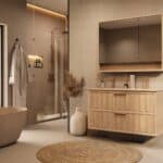 Het Riva badkamermeubel 120 in naturel eiken combineert ambachtelijk vakmanschap met moderne luxe. Gemaakt van massief eiken met ribbelfront, twee softclose lades en een mat beige dubbele Mineraalsteen wastafel. De wastafel kan met of zonder kraangat