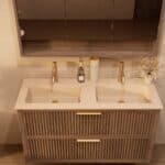 Het Riva badkamermeubel 120 in donker eiken ademt luxe en rust. Massief eiken met groevenfront, twee hoogwaardige softclose lades en een mat beige Mineraalsteen dubbele wastafel. De wastafel kan met of zonder kraangaten worden geleverd.