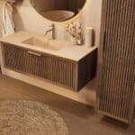 Het Riva badkamermeubel 120 in donker eiken ademt luxe en rust. Massief eiken met groevenfront, hoogwaardige softclose lades en een mat beige Mineraalsteen wastafel. De wastafel kan met of zonder kraangaten worden geleverd.