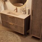 Het Riva badkamermeubel 120 in donker eiken ademt luxe en rust. Massief eiken met groevenfront, twee hoogwaardige softclose lades en een mat beige Mineraalsteen wastafel. De wastafel kan met of zonder kraangaten worden geleverd.