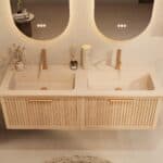 Het Riva badkamermeubel 140 in naturel eiken combineert ambachtelijk vakmanschap met moderne luxe. Gemaakt van massief eiken met ribbelfront, softclose lades en een dubbele mat beige Mineraalsteen wastafel. De wastafel kan met of zonder kraangaten wo