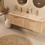 Het Riva badkamermeubel 140 in naturel eiken combineert ambachtelijk vakmanschap met moderne luxe. Gemaakt van massief eiken met ribbelfront, softclose lades en een dubbele mat beige Mineraalsteen wastafel. De wastafel kan met of zonder kraangaten wo
