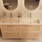 Het Riva badkamermeubel 140 in naturel eiken combineert ambachtelijk vakmanschap met moderne luxe. Gemaakt van massief eiken met ribbelfront, vier softclose lades en een mat beige dubbele Mineraalsteen wastafel. De wastafel kan met of zonder kraangat