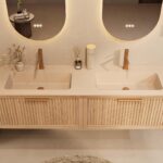 Het Riva badkamermeubel 160 in naturel eiken combineert ambachtelijk vakmanschap met moderne luxe. Gemaakt van massief eiken met ribbelfront, softclose lades en een dubbele mat beige Mineraalsteen wastafel. De wastafel kan met of zonder kraangaten wo