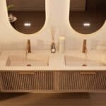 Het Riva badkamermeubel 160 in donker eiken ademt luxe en rust. Massief eiken met groevenfront, hoogwaardige softclose lades en een mat beige Mineraalsteen dubbel wastafel. De wastafel kan met of zonder kraangaten worden geleverd.