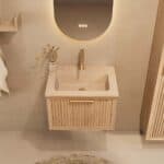 Het Riva badkamermeubel 60 in naturel eiken combineert ambachtelijk vakmanschap met moderne luxe. Gemaakt van massief eiken met ribbelfront, softclose lades en een mat beige Mineraalsteen wastafel. De wastafel kan met of zonder kraangaten worden gele