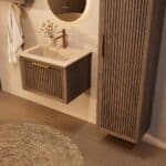 Het Riva badkamermeubel 60 in donker eiken ademt luxe en rust. Massief eiken met groevenfront, hoogwaardige softclose lades en een mat beige Mineraalsteen wastafel. De wastafel kan met of zonder kraangaten worden geleverd.