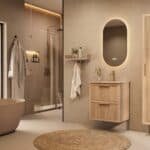 Het Riva badkamermeubel 60 in naturel eiken combineert ambachtelijk vakmanschap met moderne luxe. Gemaakt van massief eiken met ribbelfront, twee softclose lades en een mat beige Mineraalsteen wastafel. De wastafel kan met of zonder kraangaten worden