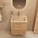 Het Riva badkamermeubel 60 in naturel eiken combineert ambachtelijk vakmanschap met moderne luxe. Gemaakt van massief eiken met ribbelfront, twee softclose lades en een mat beige Mineraalsteen wastafel. De wastafel kan met of zonder kraangaten worden