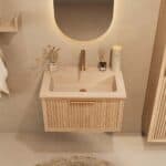 Het Riva badkamermeubel 70 in naturel eiken combineert ambachtelijk vakmanschap met moderne luxe. Gemaakt van massief eiken met ribbelfront, softclose lades en een mat beige Mineraalsteen wastafel. De wastafel kan met of zonder kraangaten worden gele